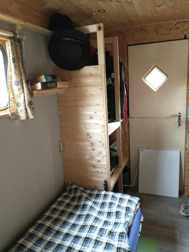 Innenansicht des Bauwagen - Garderobe und Bett